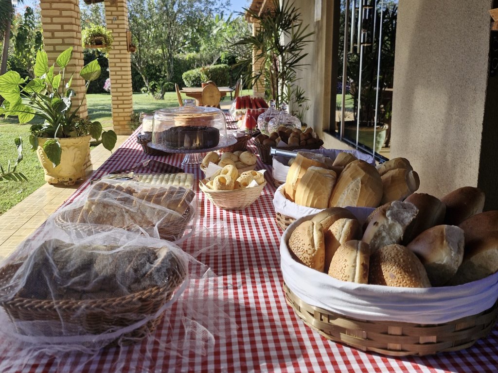 Café colonial com pães e bolos servido na varanda do haras